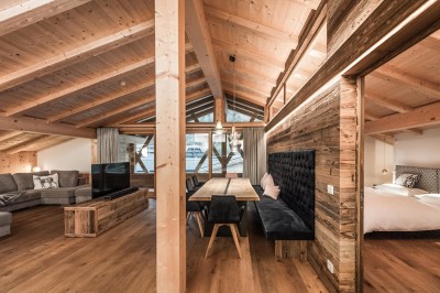 Penthouse mit großem Esstisch, Fernseher und großzügiger Couch