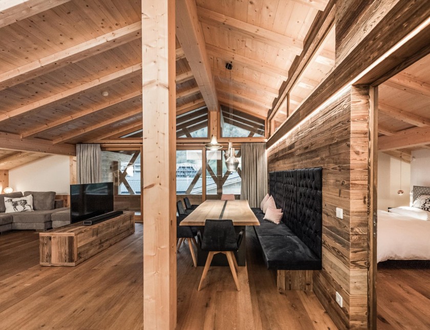 Penthouse mit großem Esstisch, Fernseher und großzügiger Couch