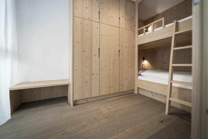 Stockbett mit Holzleiter und Kleiderschrank