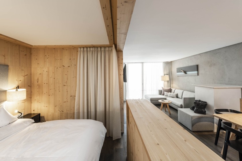 Doppelbett mit Vorhang abtrennbar und Couch im Hintergrund