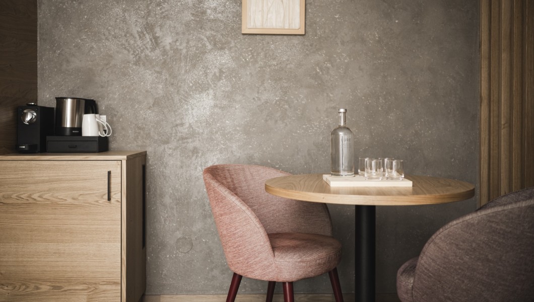 Kleiner runder Tisch mit Glasflasche und Gläser mit Stuhl