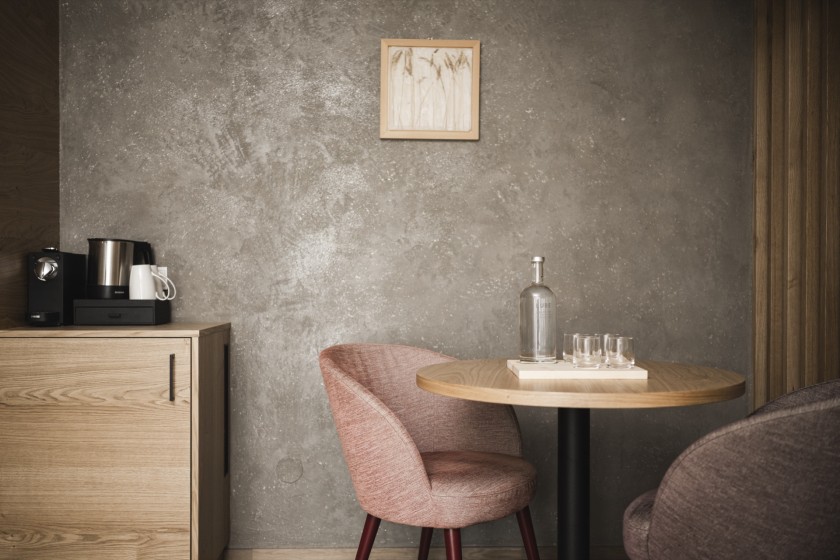 Kleiner runder Tisch mit Glasflasche und Gläser mit Stuhl